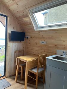 马莱格Mallaig Glamping Pods的一间带木桌和水槽的小厨房