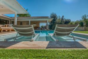 奥皮约la villa miel的游泳池旁的两把椅子