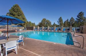 弗拉格斯塔夫Club Wyndham Flagstaff的一个带椅子和遮阳伞的大型游泳池