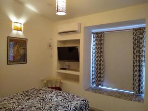 巴兰基亚La Habitación Perfecta的一间卧室设有一张床、一个窗口和一台电视