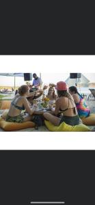 萨玛拉LA DOLCE VITA - on the Beach - Samara的一群穿着泳衣的妇女在海滩上坐