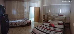 伊瓜苏港Alojamiento Aparecida的酒店客房设有两张床和电视。