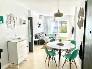 奇克拉纳－德拉弗龙特拉Apartamento La Barrosa的厨房以及带桌椅的起居室。