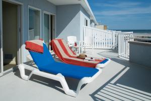 威尔伍德克拉斯特夏利马尔度假酒店的阳台的蓝色和红色躺椅