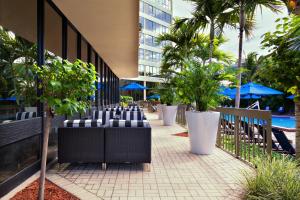 海厄利亚加登斯迈阿密西机场区假日酒店的建筑物前一排椅子和树木