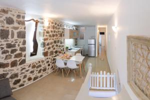 伊兹拉Sokaki House的厨房配有白色的桌子和石墙