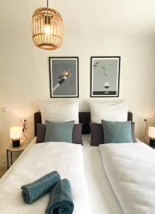 科赫姆Haus Mosel Tales in Cochem für bis zu 9 Personen的卧室配有2张白色的床和吊灯。