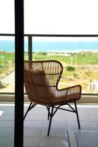 纳哈里亚4 Bedroom Beach Apartment with Stunning Views的坐在窗前的柳条长凳