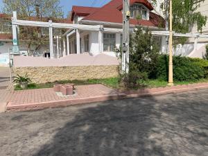 康斯坦察Pensiunea Casa Harghita的一条白色房子,在街道前有砖砌的人行道