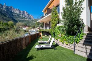 莫尼斯特罗尔Apartaments Agulles de Montserrat的阳台配有2把躺椅(位于草地上)