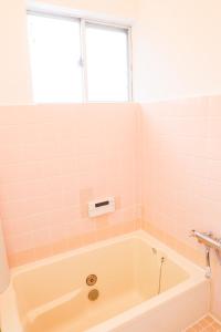 KōriyamaHAT Kujo, near from Kintetsu Kujo station 近鉄九条駅前の民泊的浴室设有浴缸,铺有粉红色的瓷砖。