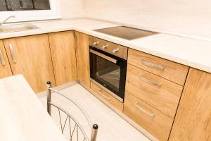 奥拉迪亚Urban Retreat Luxury HideAway的厨房配有木制橱柜、水槽和炉灶。