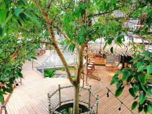 班邦宝The Mud - Eco Hotel的木甲板上种有树,配有桌椅
