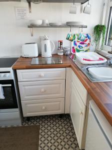 伊费林赫利Uwch Menai的厨房配有白色橱柜和台面