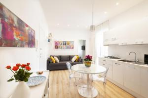 巴里Traiano Luxury Home的白色的厨房以及带桌椅的客厅。