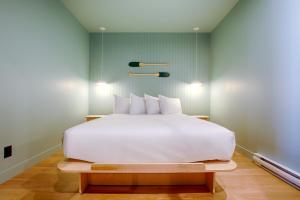 魁北克市Les Lofts Dorchester - Par Les Lofts Vieux-Québec的一张白色大床,位于带绿色墙壁的房间