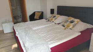 科隆艾根史坦酒店的一张配有白色床单和枕头的大床