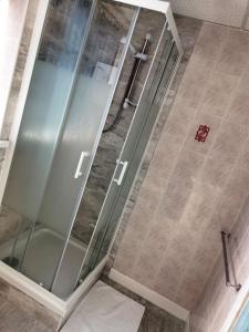 布莱克浦舍伍德酒店的浴室里设有玻璃门淋浴