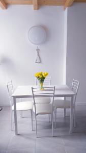 克里日亚Residenza Solferino的一张带椅子的白色桌子和花瓶