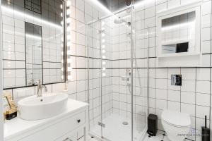 梅尔诺Apartament Black的白色的浴室设有水槽和淋浴。