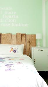 莱万托Amandolevanto B&B的卧室配有白色的床和木制床头板