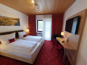 梅特斯多夫卡洛斯穆赫兰葡萄酒庄酒店的配有一张床和一张书桌的酒店客房