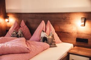 迈斯霍芬Appartement Pointschneiderhof的一间卧室配有一张带红色和白色枕头的床