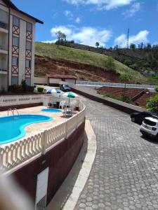阿瓜斯迪林多亚Apartamento Diamante的停车场旁的一座带游泳池的建筑