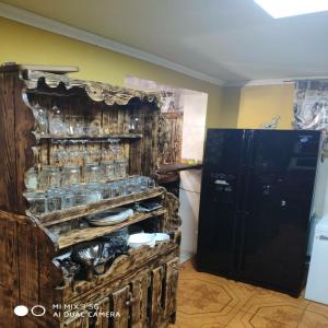 蒂拉斯波尔Like Home Hostel的厨房配有带餐具和冰箱的木制橱柜