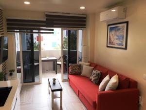 英格兰海滩Atlantic Coast Apartment - Playa Del Inglés的客厅配有红色的沙发和桌子