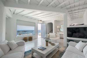 萨鲁Villa Isabella - Psarou的客厅配有白色家具和大窗户
