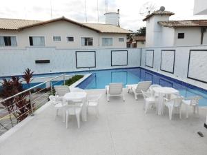 塞古罗港apartamento 2 quartos em Porto segur BA的一个带白色桌椅的庭院,毗邻游泳池