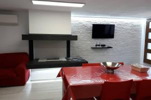 托尔托利Incantos Charme B&B & Apartment的客厅配有红色桌子和电视