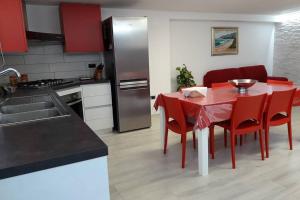 托尔托利Incantos Charme B&B & Apartment的厨房配有红色椅子和冰箱