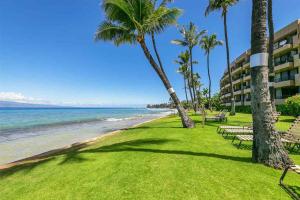 基黑Wonderful Maui Vista-Kihei Kai Nani Beach Condos的享有棕榈树海滩和大楼的景色