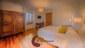 圣拉斐尔Posada El Alcornoque的一间卧室配有一张大床和一个木制梳妆台