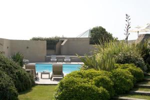 勒克鲁西克海洋堡垒酒店的一座有灌木丛的庭院内的游泳池