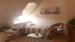 Juigné-sur-Loirela noue aubert的一间卧室配有一张床、两把椅子和一张桌子