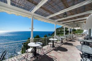 普莱伊亚诺普阿诺马雷斯卡酒店的一个带桌椅的庭院和大海
