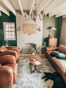 比勒陀利亚Battiss Guest House的客厅配有真皮沙发和桌子