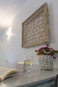伊兹拉Sokaki House的坐在桌子旁看书的一杯葡萄酒