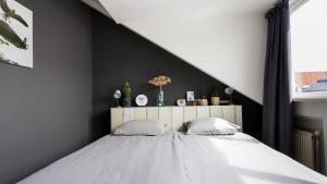 海边的艾格蒙特HuisjehurenEgmond的一间卧室设有一张大床和黑色墙壁