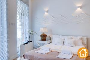 米兹多洛杰Apartamenty Marea - visitopl的白色卧室配有一张大床和两条毛巾
