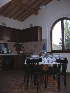 蒙塔尔奇诺韦基亚门度假屋的厨房配有带黑色椅子的桌子和窗户。