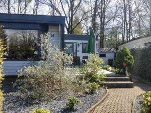 皮滕Traum-Chalet für Urlauber in Putten an der Veluwe Krachtighuizerkern 22 & free Bikes的一座花园,位于一座带庭院的房屋前