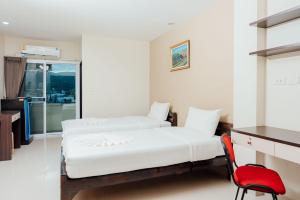 合艾康纳万住宅公寓的一间卧室配有两张床和红色椅子