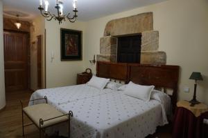 阿里纳斯·德·卡伯瑞勒斯Apartahotel Montecaoru的一间卧室设有一张大床和石墙