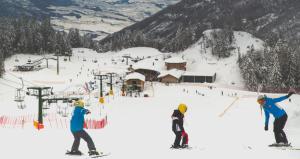 卡韦达戈Villa dei Fiori的滑雪胜地滑雪缆车上的三人