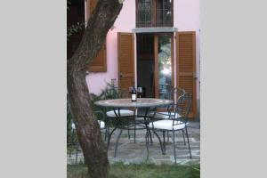 萨拉科马奇纳Romantica La Filanda的粉红色房子前面的一张桌子和椅子