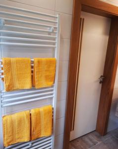 奥西亚歇尔湖畔施泰因多夫Apartment Fischer mit Privatstrand的浴室内带黄毛巾的毛巾架